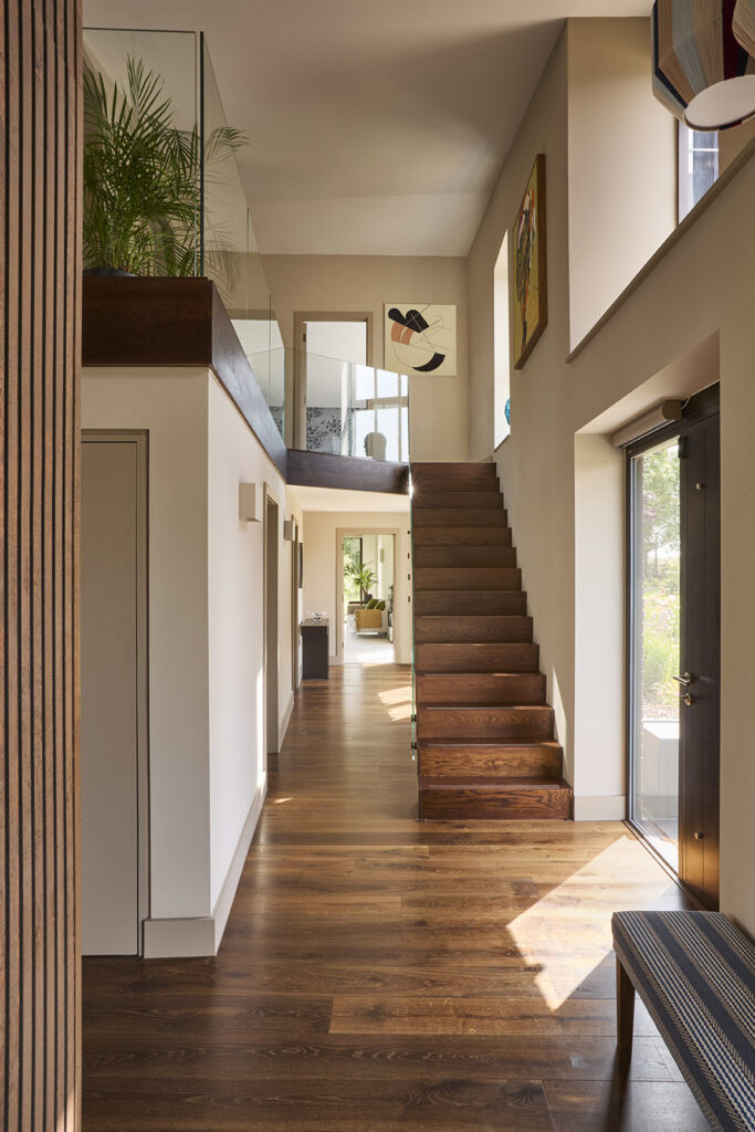 Large light-filled hallway reaches into four large bedrooms each with en suite bathroom. Timber floor and panels, floor-to-ceiling windows.