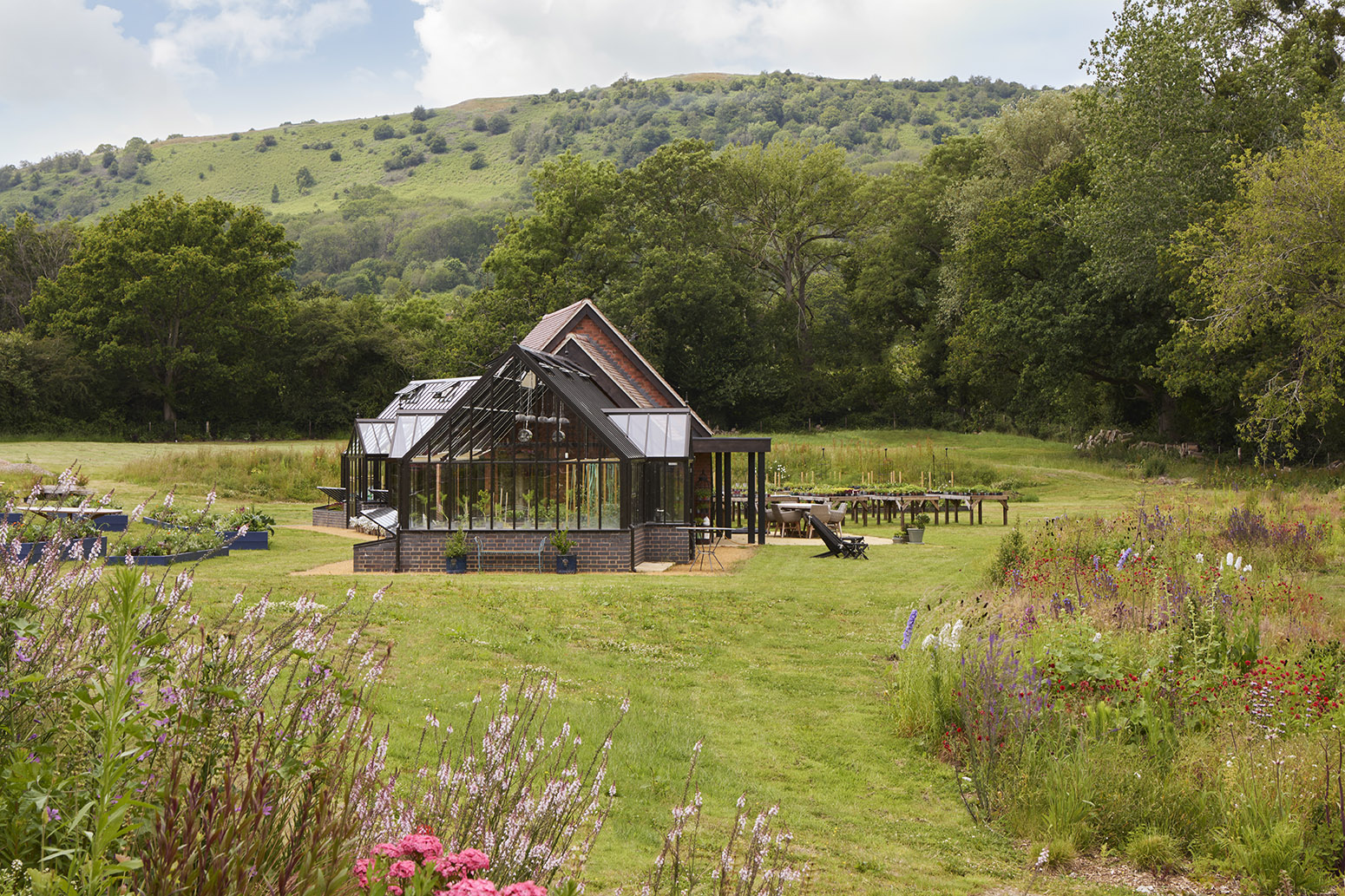 Two Hartley Botanics greenhouse frame a large garden room and kitchen with a stunning backdrop of the Malvern Hills.