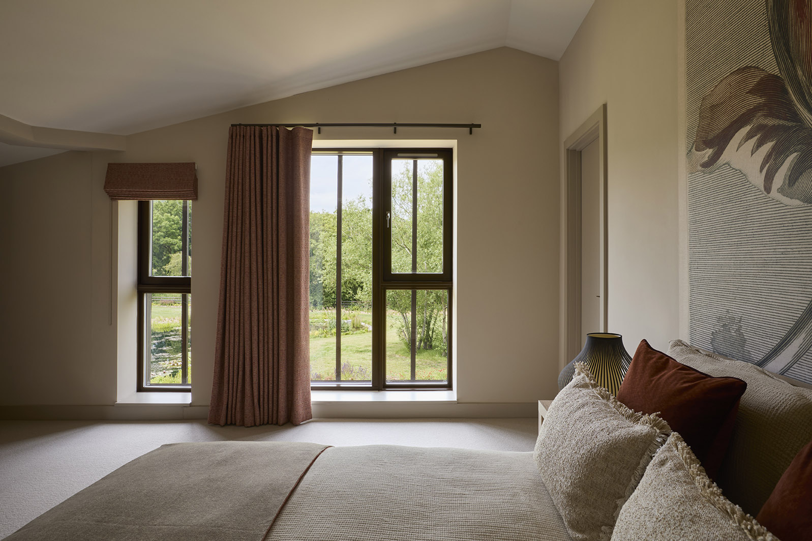 A natural palette and soft textures define this second bedroom overlooking the pond and extensive landscaped garden.